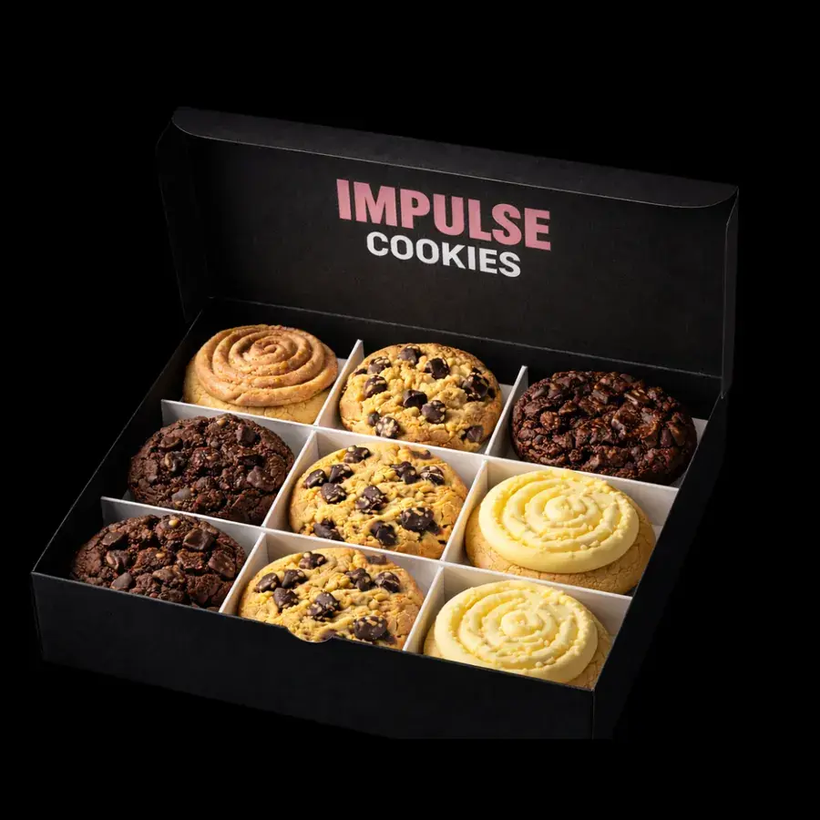 Caja negra Impulse Cookies abierta con 9 cookies chunky de distintos sabores